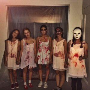 Archer Seniors, (from left to right) Phoebe Bell '15, Michelle Johnson '15, Casey Abrahams '15, Nicole Schneider '15 and Auveen Dezgaran '15 pose as dead girls in their bloody costumes, ready to scare students and teachers in the haunted house. Photographer: Scarlett Hopper '15