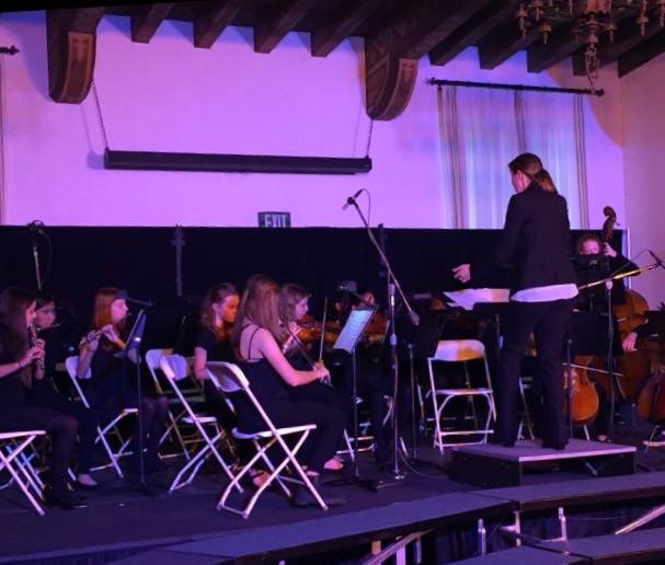 Susan Smith leads the middle school orchestra in song as they preform for the audience. Photographer: Isabelle Wilson'17