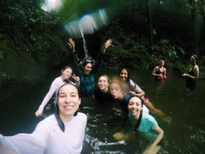 Juniors swimming under a water fall in a rainforest. Used with permission from: Avery Bush 