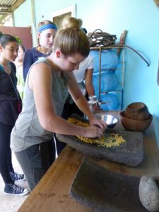 Rachel Lauster was grinding corn to make a tortilla at the Mayan Cultural Center. Used with permission from: Shohfi