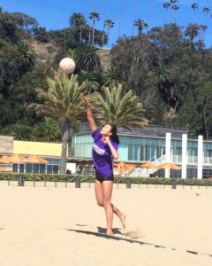 Aloha Suto '19 serves the ball. A beach volleyball is softer, lighter and a little bigger than an indoor ball. Image courtesy of Suto.