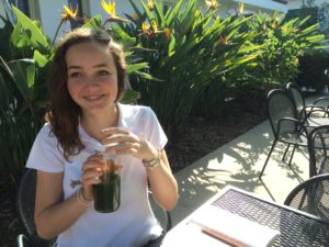 Emerson Krull '15 sits in the courtyard during a free period, sipping a vegan drink called Marjan's Favorite from Kreation Juice. Photographer: Rachel Magnin 
