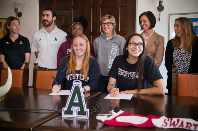 Namazie and OConnor excitedly sign their letters of intent.  They are surrounded by members of the Archer faculty.  Photographer: Daniel In