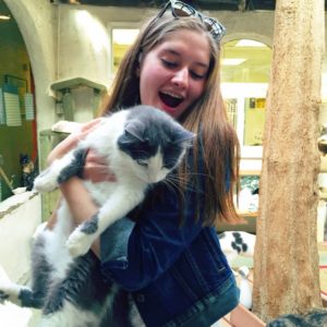 Maddie Arzt '16 cuddles with a cat at the Lange Foundation. Volunteers are always needed to play with the cats so they get used to being around humans. Picture used with permission from Maddie Arzt '16.