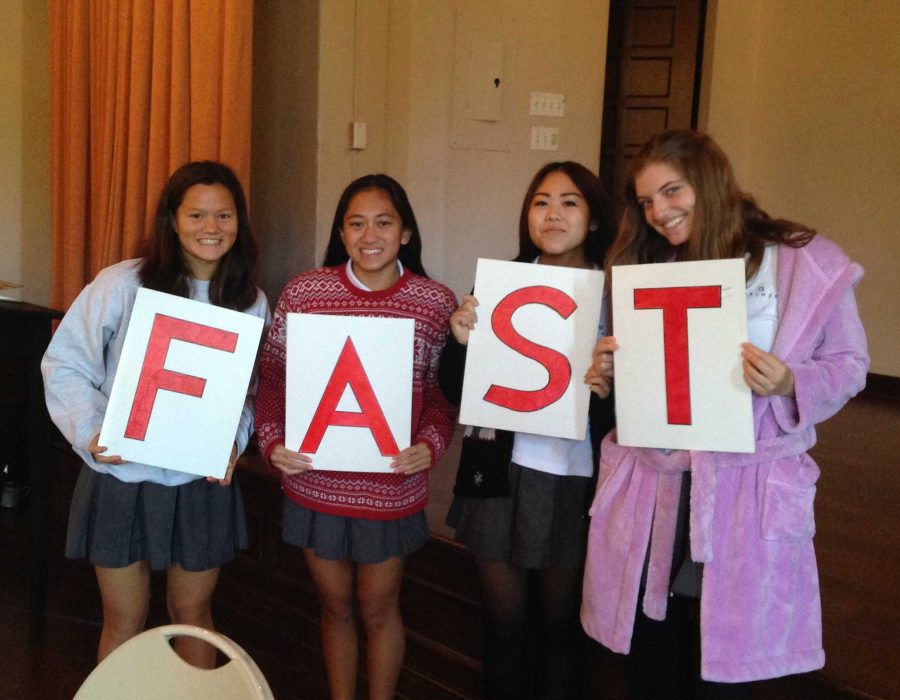 From left to right, Saskia Wong-Smith, Summer de Vera, Sydney Shintani, and Sara Friedman all 18 hold up FAST signs. They taught the 6th-graders about hunger and shared the acronym FAST, standing for fundraise, advocate, shop wisely and teach, as way for the 6th-graders to remember how to prevent hunger. 