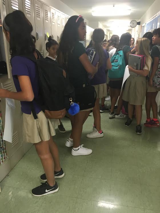 Seventh grade students congregate in hallway. The seventh grade is one of the classes that Peer Support focuses attention on in their presentations.