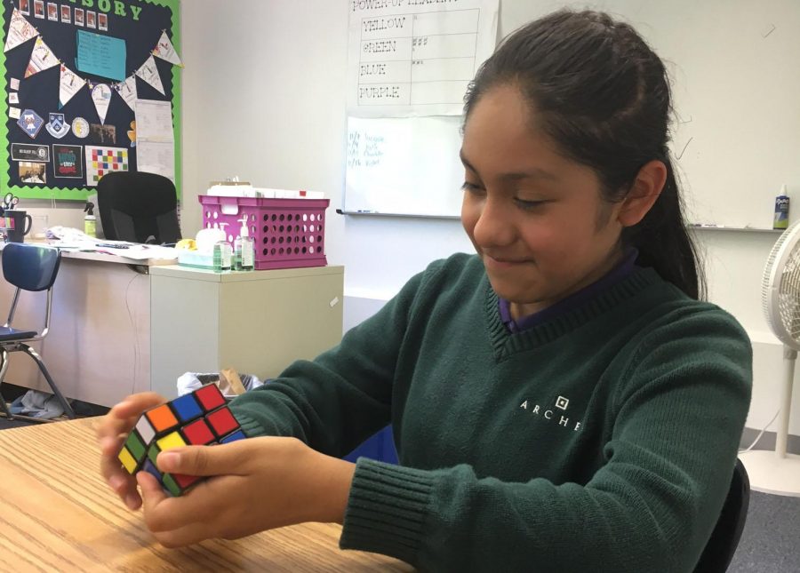 Karen Garcia 23 solves a Rubiks Cube at the teams first meeting. The team completed a simple practice mosaic after brainstorming design ideas. 