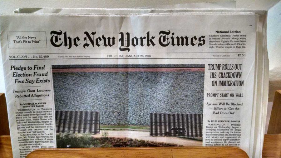 A picture of New York Times articles discussing Trumps discriminatory policies. One of the headlines reads, Trump Rolls Out His Crackdown on Immigration.