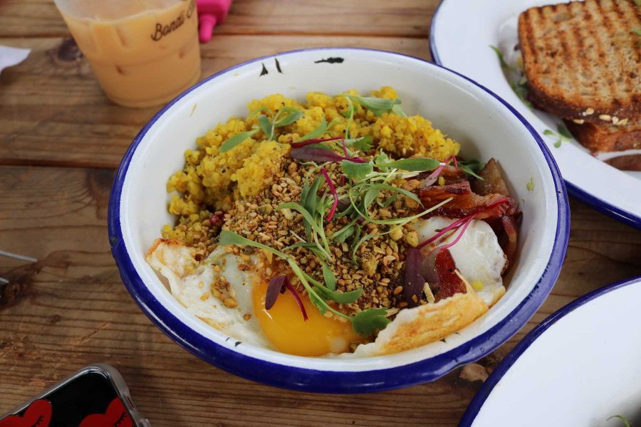 The Caveman Bowl sits on a table. The gluten-free dish consists of turmeric quinoa, bacon, fried egg, cauliflower rice, kale and homemade hummus. Many of the menu items from Bondi Harvest include seasonal and locally-sourced ingredients. 