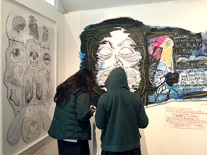 Students observing Sarah Walstons senior show titled Exploring the American Monster. 