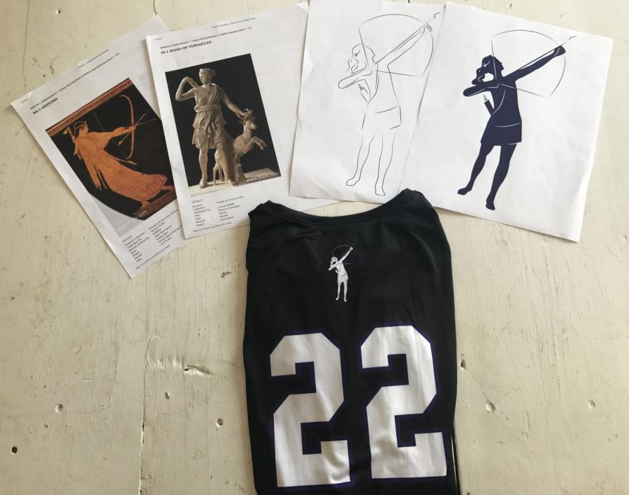 A volleyball jersey with the new athletics Artemis logo sits on a table with Laurel Bybees research on the goddess and her final designs. The new logo is on the back of every Archer sports jersey. 