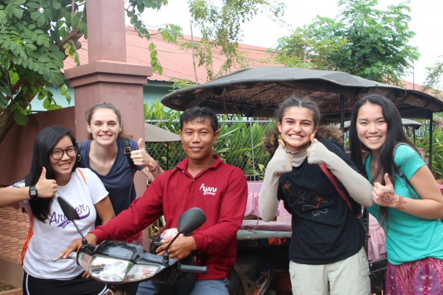 Archer Students Ruby Colby 19, Rachael Boehm 18 , Megan Escobar 19 and Bea Freeman 19 pose with a Cambodian driving a tuk-tuk. The photo was taken in Phnom Penh.