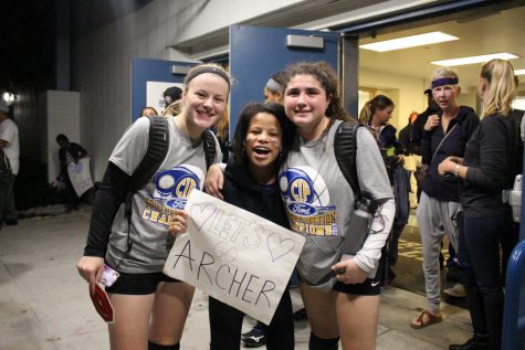 Varsity volleyball team members Alex Feldman 18 (left) and Macoy Ohlbaum 18 (right) pose for a photo with Jayla Brown 18 (center). The varsity volleyball team will be advancing to the state championship.