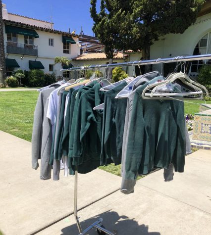 A rack of Archer uniforms, which people donated for an Archer clothing drive that I co-organized earlier this month. The clothes are primarily green, white, black and gray. 