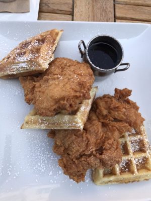My delicious dinner consisting of a deep-fried chicken breast and delicious rosemary waffle covered in powered sugar. Soho Chicken and Whiskey is located in Cleveland, Ohio. 