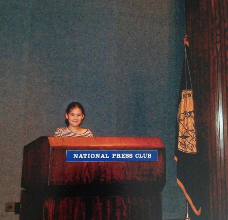 An eight-year-old me poses behind the podium of the National Press Club in Washington D.C. My first taste of journalism came on that trip, where my parents and I visited a family friend, who was a former White House correspondent.