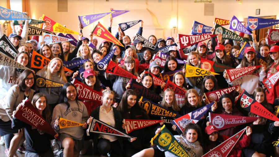 The Class of 2018 and Head of School Elizabeth English pose in the Rose Room with pennants. The seniors, along with Gwen Strasberg 19, participated in the pennant-hanging event.
