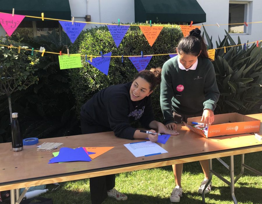 Juliet Youssef 19 and Hannah Kim 20 facilitate pennant-making for International Day of the Girl and National Coming out Day. 