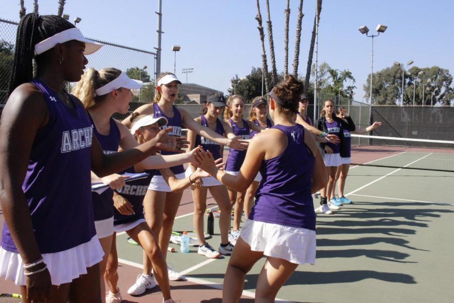The varsity Archer tennis team cheer each other on before a game. The team is comprised of freshman through seniors. 
