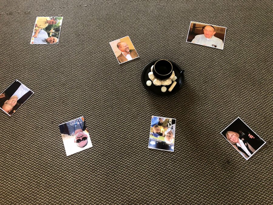 Pictures lie on the ground of the HD room, featuring seven victims of the Tree of Life synagogue shooting in Pittsburgh. JSC placed the pictures around a bowl with candles to honor the victims memories. 