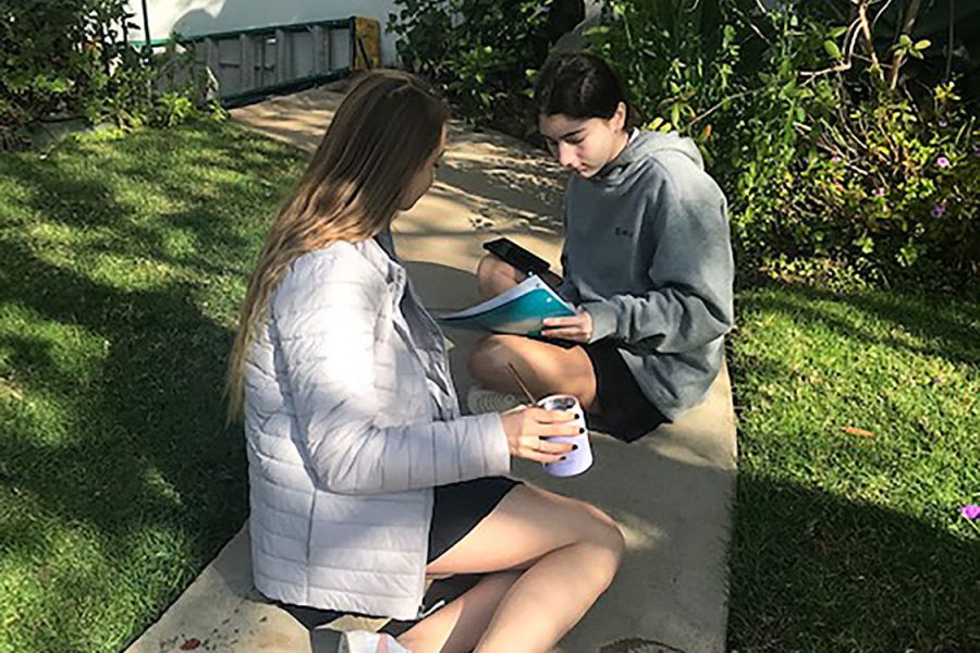 Freshmen London Sinclair and Chloe Fidler sit in the shade in the courtyard during x-block. The lavender grey color of the jacket really compliments our uniform colors. Sinclair said.
