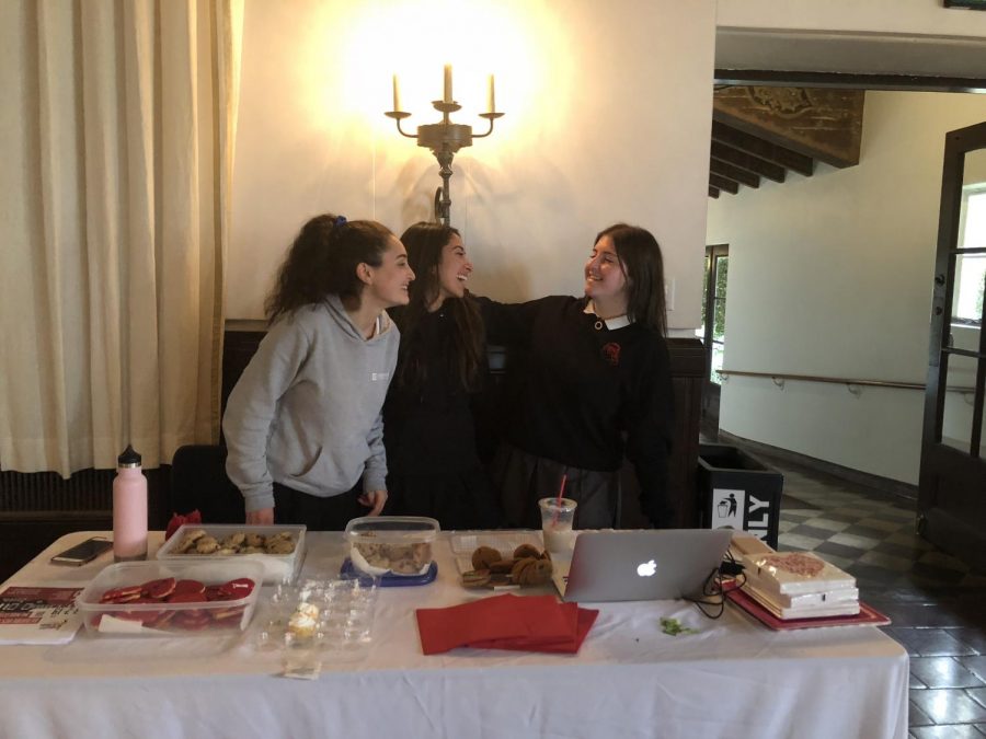 HEARTbeats club leaders Casey Nuss, Leila Miramadi, and Nicki Rosenberg stand behind the table for their bake sale. The three juniors sold treats to benefit the Violence Intervention Program. 