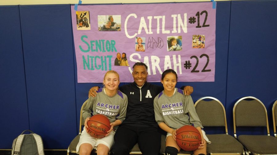 Seniors Sarah Traenkle and Caitlin Chen sit next to their coach, Jelani Bandele. At Thursdays game, the team celebrated Senior Night, which honored Chen and Traenkle. 