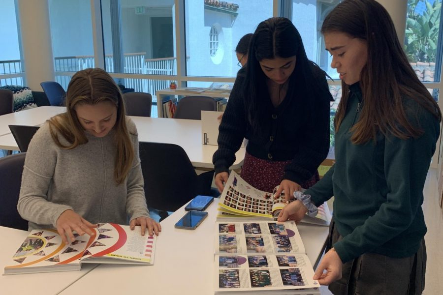 Yearbook copy editor Abigale Lischak 20, photo editor Yasi Gohar 20, and sales manager Julia Wanger 20 flip through the pages of this years yearbook. The theme of the book is HERizon. 