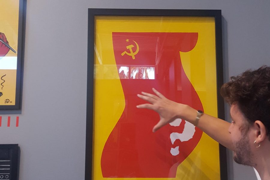A guide explains one of the posters in the exhibit, Perestroika, created by Alexander Amelin in 1988, two years before the Soviet Unions collapse. The poster presents the red silhouette of a pregnant woman marked with the communist symbol. According to the Wende Museum brochure, the unborn child, designated with the large question mark, highlights the uncertainty [of the future of Russia]. 