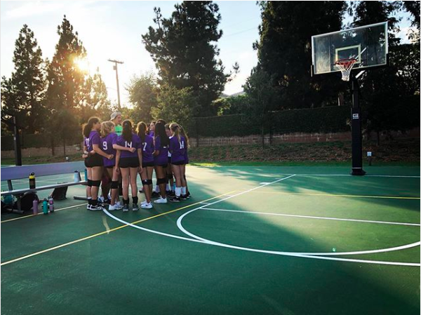 The purple volleyball team, led by sixth grader Juliette Hoeber and seventh grader Callie Wicklander, gathers in a huddle on Archers Sport Court. The team is composed mainly of new Archer students, and a sense of unity was a main goal for both Hoeber and Wicklander. 