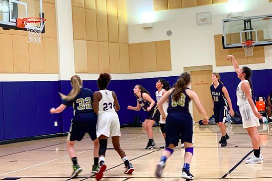 Junior Ariel Heimanson attempts a shot in the first varsity basketball game of the season against Vistamar School on Nov. 19. The team won with the score of 30-21.