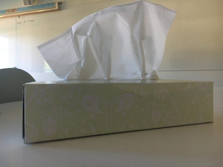 A box of tissues sits on a classroom desk. During finals week, students came to school despite being sick.