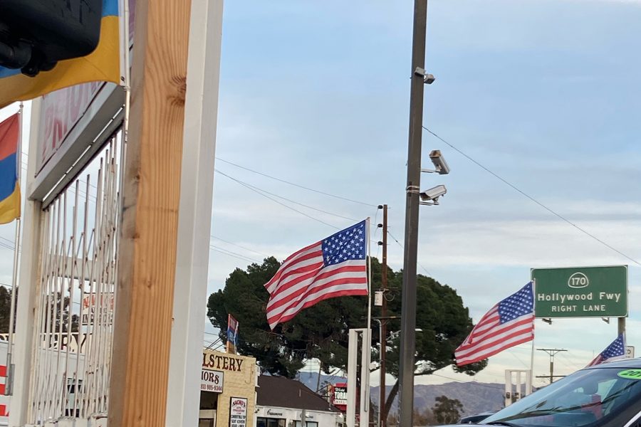 An American flag waves over a car dealership in Los Angeles, California. Amid the insurrection, the American flag was one of the many examples of paraphernalia displayed at the storming of the Capitol. Pro-Trump supporters held up and waived this flag during the Save America march, that later turned into a violent rioting event, where the Capitol was ransacked and breached.