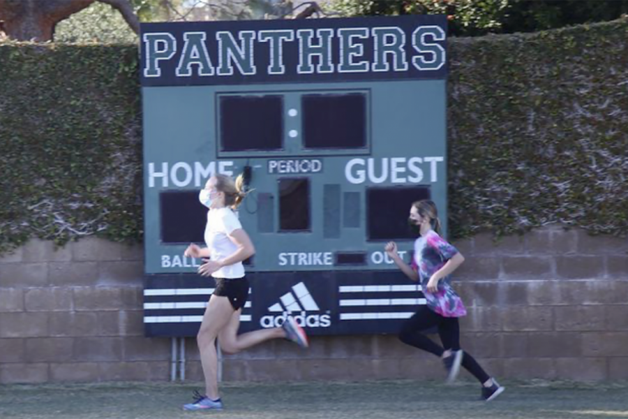 Athletes Lauren Robson (22) and Kate Hanney (25) run on the Archer field during an Archer cross country practice. COVID-19 regulations have changed in L.A. county, allowing for Archer athletics to return to sports practices and some competitions.