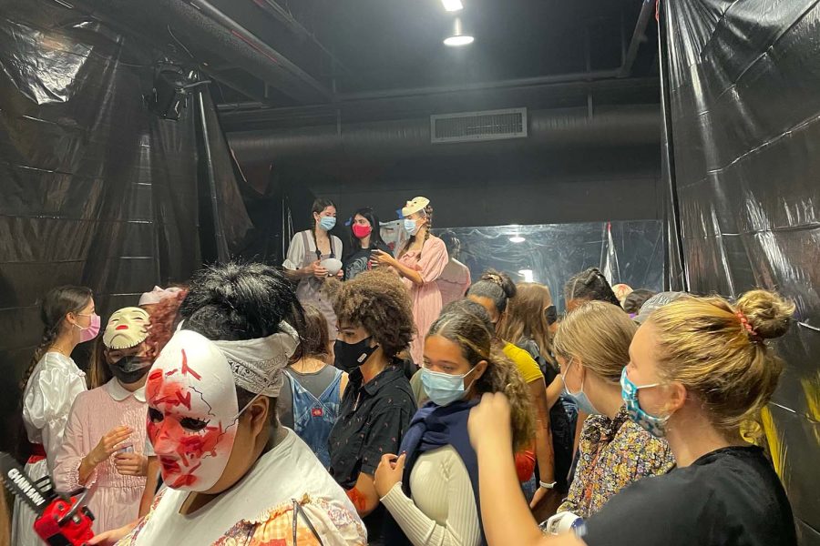 Seniors gather in the black box during a break amidst the haunted house run through. This has been such an integral experience for my senior year, senior Chidimma Nwafor said.
