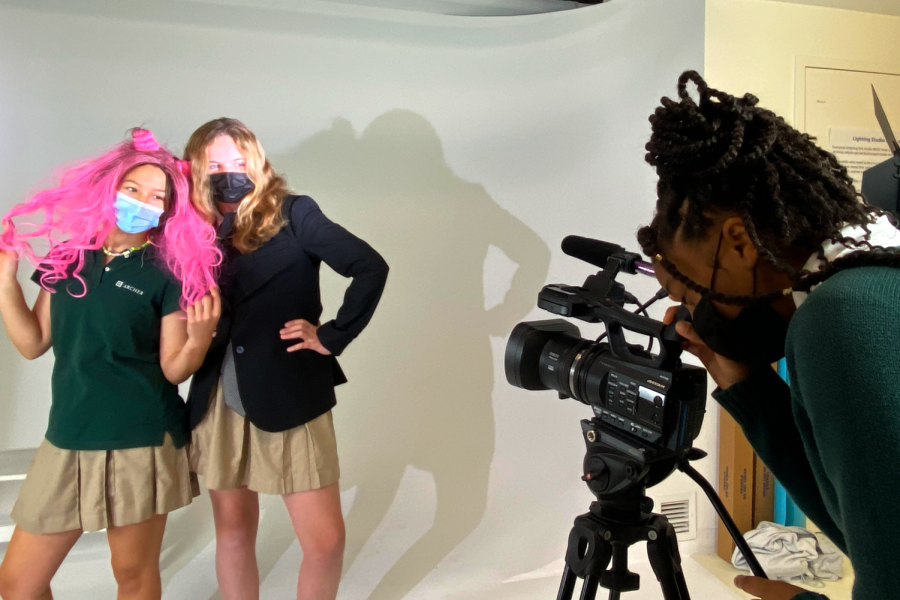 Shayla Covington (26) films Julia Ong (26) and Skylar Roberts (26) posing in the lighting studio. On Nov. 17, they filmed their cooking show segment Flop Chef for the middle school broadcast.