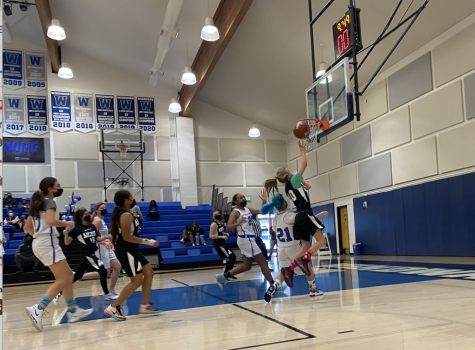 Sixth grader Bella Hansen shoots a ball at the teams last game. They played Windward last Friday, Dec. 10, where they lost 8-38. We learned the importance of having a good balance between having a strong defense and being aggressive, seventh grader, Paloma Lebenzon said.
