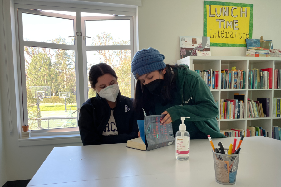 Maia Alvarez (‘24) and Charlie Clayton (‘25) look through the book “The Woman in the Window” as they discuss it in the book club. The Freshmen-Sophomore Book Club had their first meeting Jan. 25 during lunch.