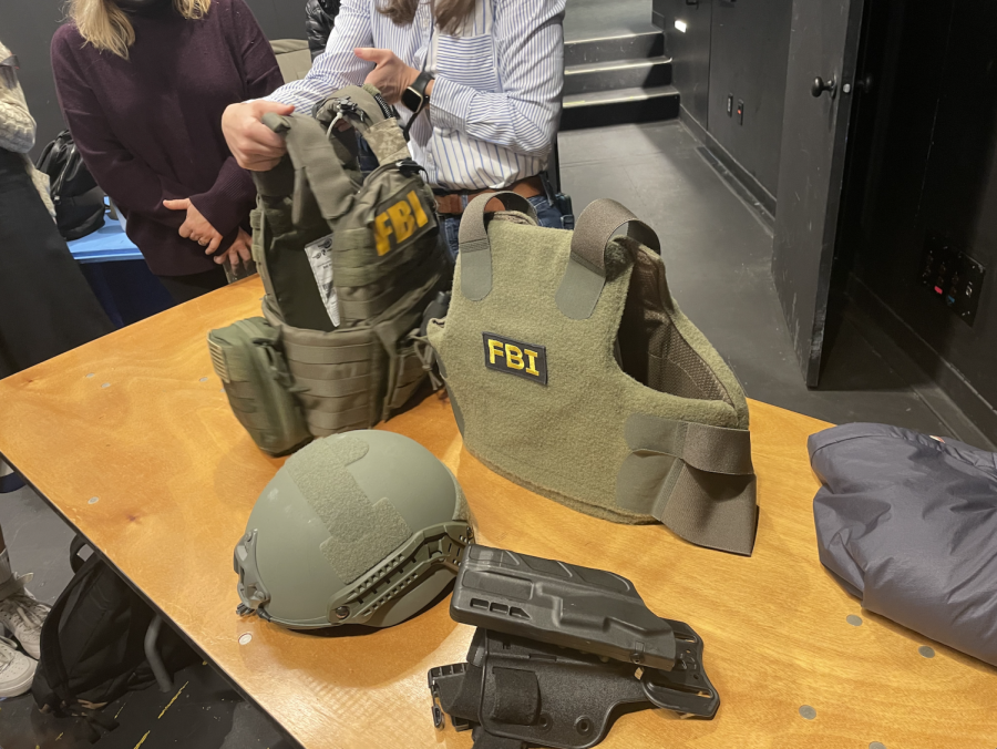 A female agent from the FBI demonstrates how bulletproof vests are worn. Students who participated in the assembly had the opportunity to try on gear following the presentation.