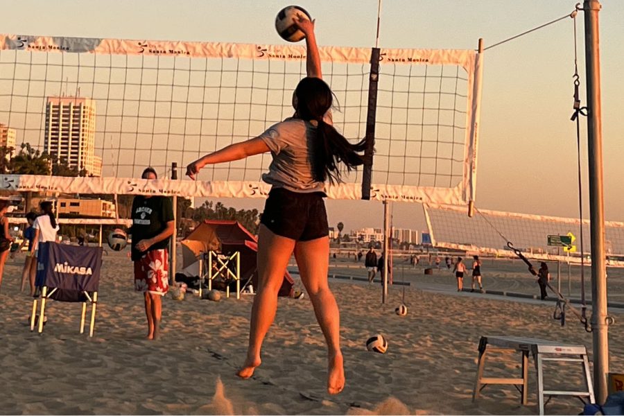 Sophomore Chloe Chu spikes the volleyball over the net during team practice at Annenberg Community Beach on Feb. 9. The team enjoys watching the sunset while bonding and staying active, teammate Tavi Memoli (25) said.