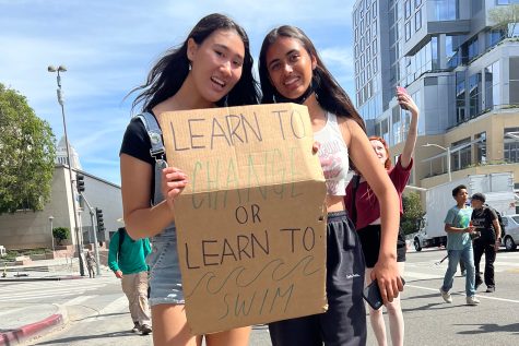 Juniors Dani Fenster and Uma Bajaj hold up a sign while marching at the Youth Climate Strike Los Angeles. The strike took place March 25 in Downtown Los Angeles, and Archer students were granted excused absences for attending.