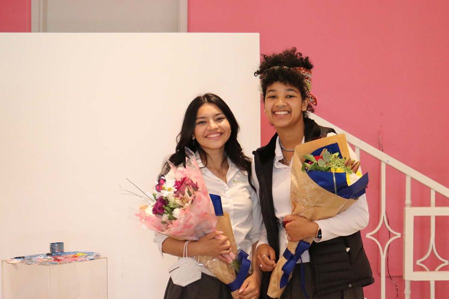 Seniors Emily Cadenas and Naobi Benjamin pose with their flowers to commence the opening of their art gallery. “Character Development” opened Wednesday, March 30, at the Eastern Star Gallery and highlighted their joint artwork about their growth as POC women. “Working with Emily  — she’s one of my best friends, so it’s cool to have a best friend who will encourage you and help you,” Benjamin said. “Our gallery was really successful because we have that trust and connection as well.”
