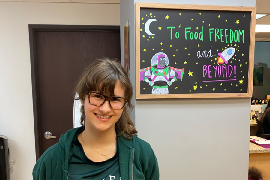 Sophomore Elle Moccio stands in front of a poster at the Southern California Food Allergy Institute as she finishes her allergy treatment there. On Dec. 3, 2019, Moccio achieved food freedom when she finished her treatment that slowly desensitized her to her peanut allergy.