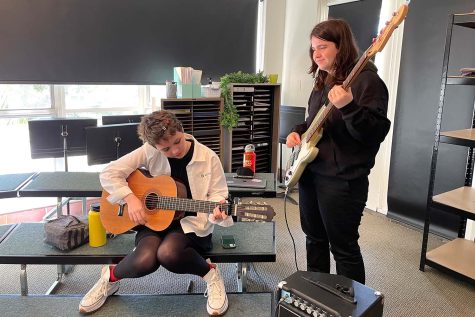 Sophomores Nita Kelly and Megan Kelley practice chosen jazz and rock songs on their instruments. The jazz and rock band members met in the choir room March 29 to continue rehearsing their songs together.