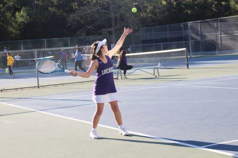 Purple team player Phoebe Miro (28) throws the ball into the air to prepare for her next serve at the teams first match where they won 4-2 against Geffen. The middle school tennis team consists of new players and spirits that will foster friendships and improve the teams playing and community. Its not necessarily about winning, green team player Abby Berman said. Its just really fun to be able to play with my friends.