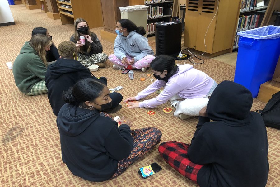 Sophomores Alejandra Cortes (24), Lacey Thompson (24), Ijeoma Nwafor (24) and Laila Charles (24), play Spot It. Other activities in the library included board and card games for students to play before or during the movie 10 Things I Hate About You.