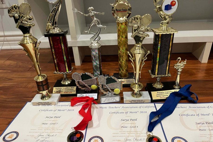A handful of trophies, medals and certificates that I have won in various activities lie on the floor. These examples of physical achievements represent the visible wins, but fail to reflect all of the hard work and challenges I faced throughout the process.