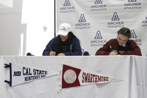 Seniors Faith Soriano and Isabella Specchierla smile as they sign their National Letters of Intent and Commitment in the amphitheater. After 12 years of training in their sports, Soriano committed to play softball at California State University Monterey Bay, and Specchierla committed to play soccer at Swarthmore University.
