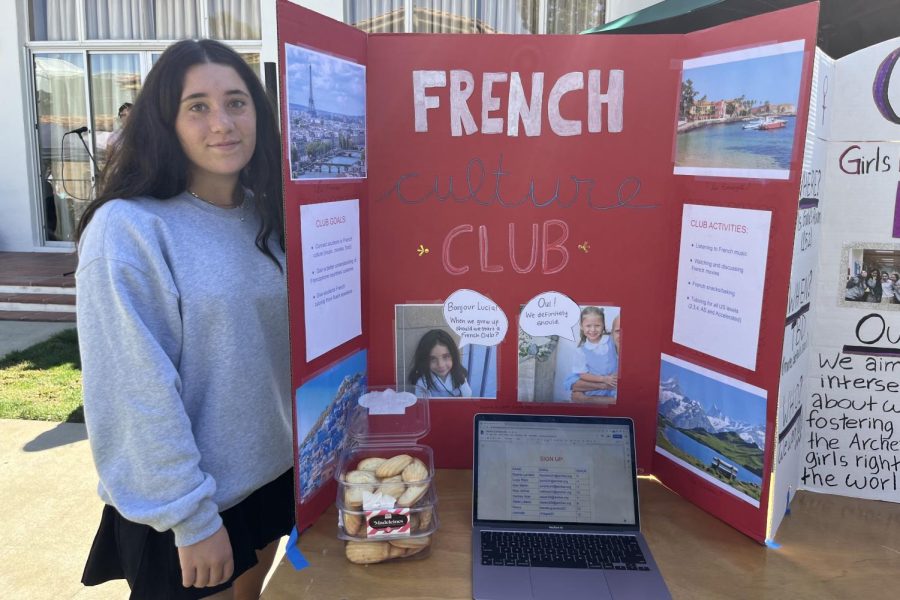 Sophia Landers (24) smiles for a photo with her club poster. Landerss club focuses on engaging with French culture.