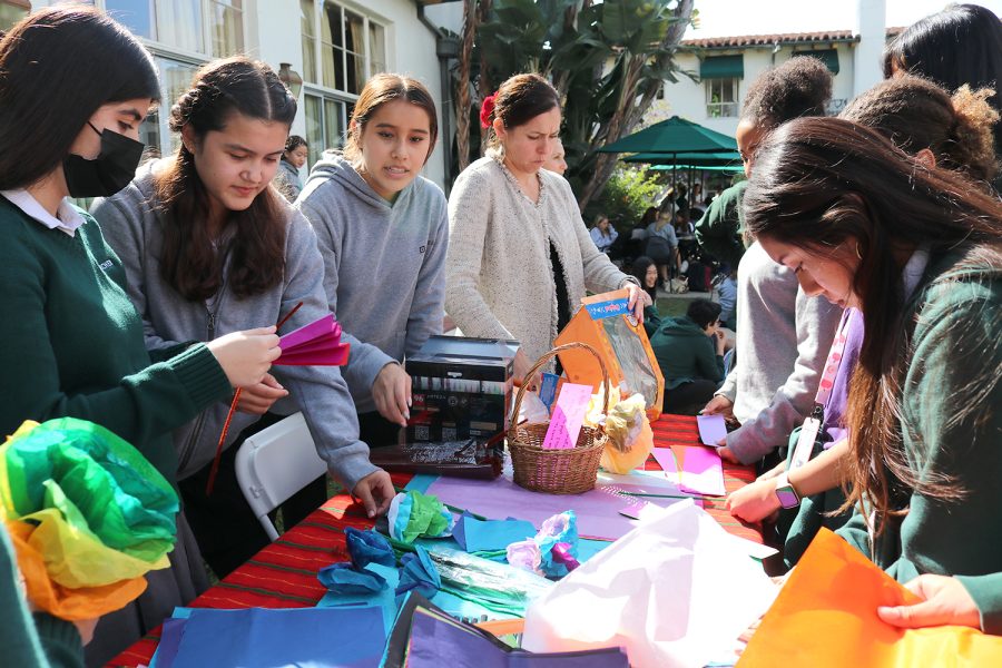 Students and Spanish teacher Annie Santana-Grush make tissue paper marigolds in honor of Día de Los Muertos. The marigolds fragrant smell and bright color were meant to attract the souls of the deceased to altars made by their families.